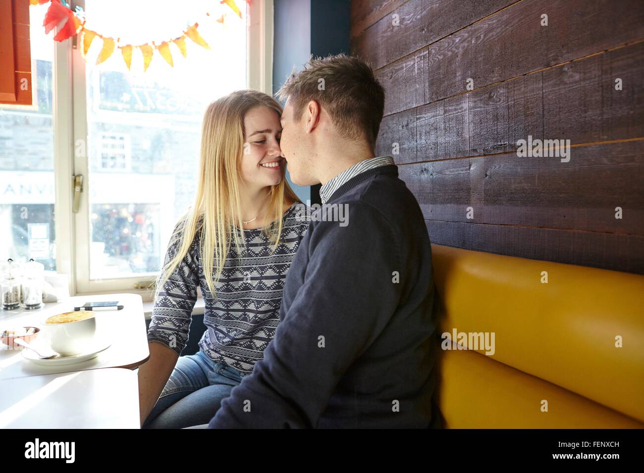 Romantische junges Paar von Angesicht zu Angesicht im Café Fensterplatz Stockfoto