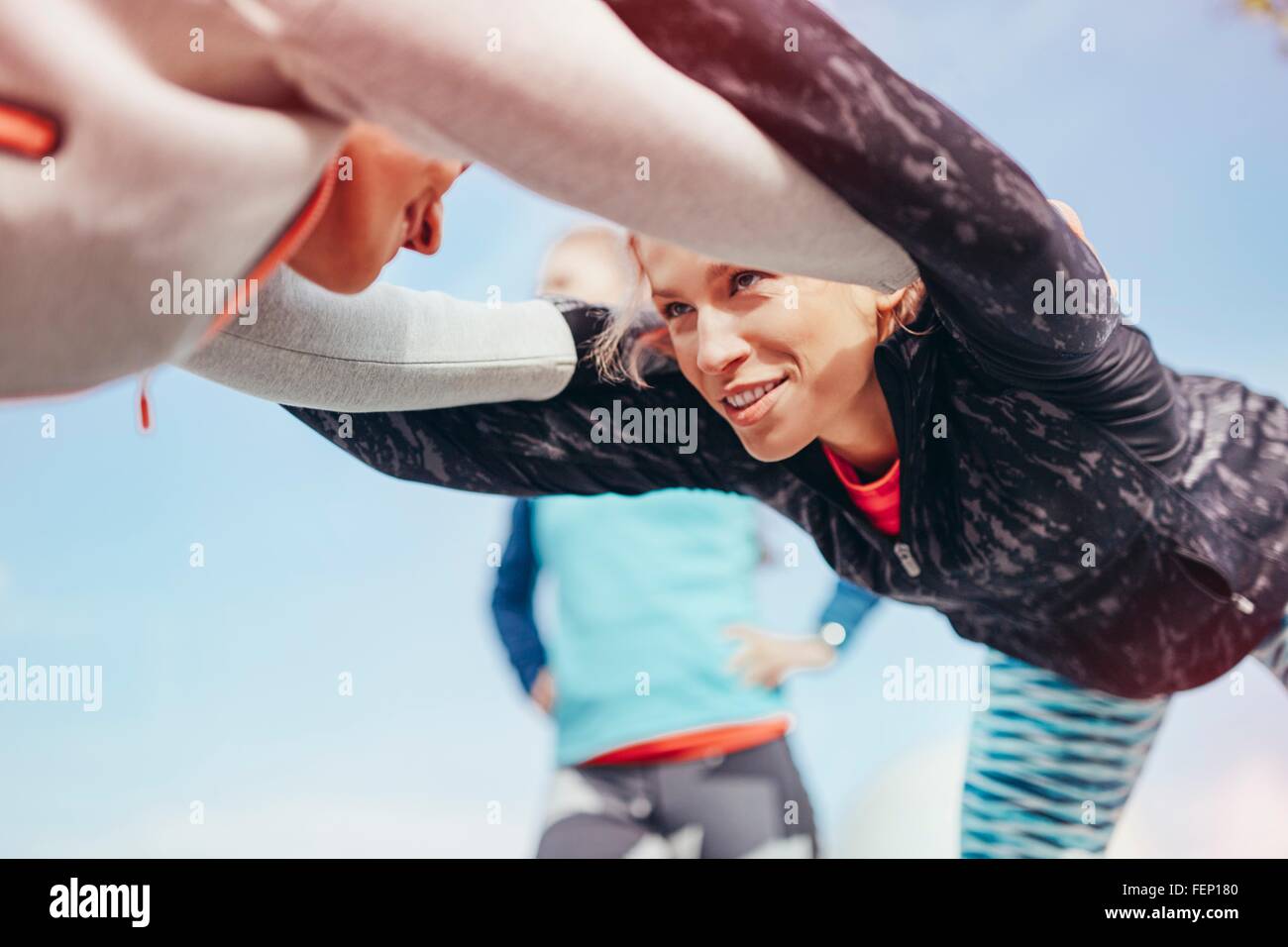 Niedrigen Winkel Blick auf zwei Läuferinnen Aufwärmübung zusammen tun Stockfoto