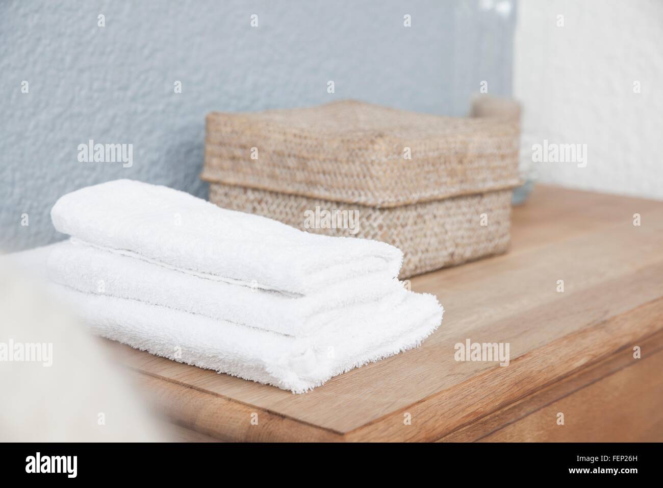 Stapel Handtücher und Box auf Kommode Stockfoto