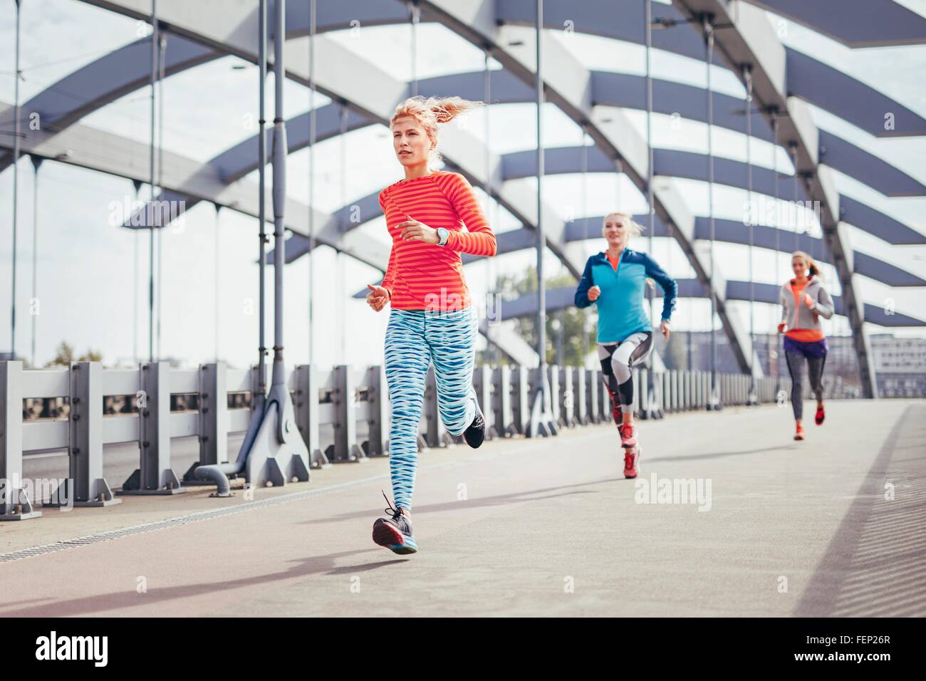 Drei weibliche Läufer quer durch Stadt Steg Stockfoto
