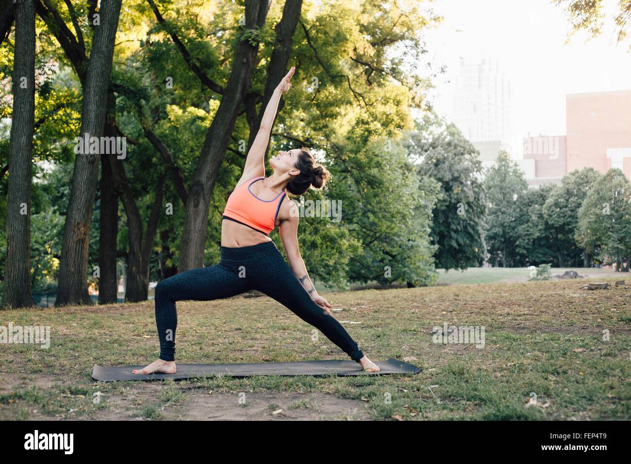 Frau in friedvoller Krieger-Pose (Parivrtta Virabhadrasana) Stockfoto