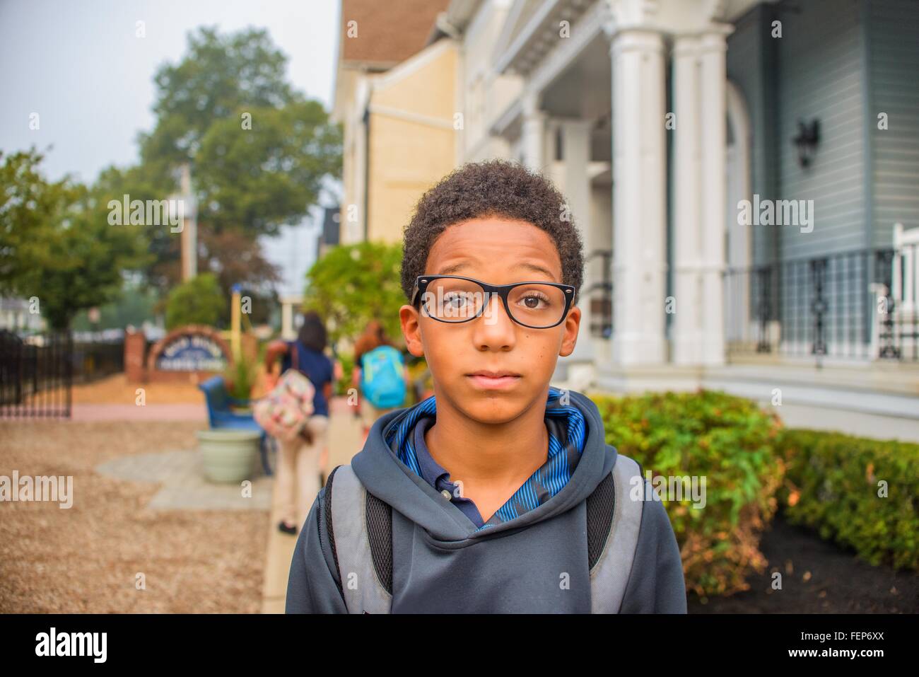 Traurige Junge stand neben Schule Stockfoto