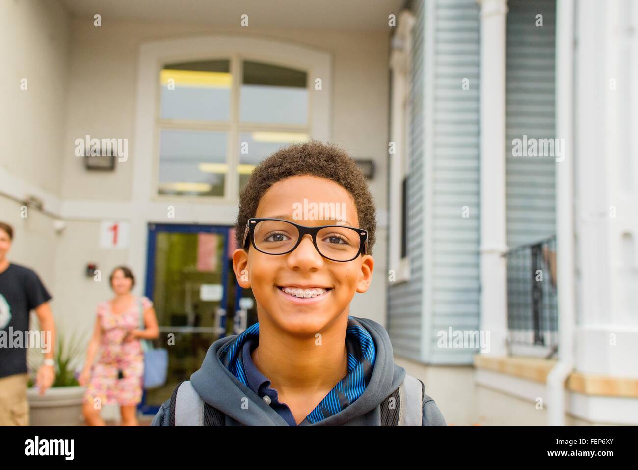 Fröhlicher Junge stehend vor Schule Stockfoto