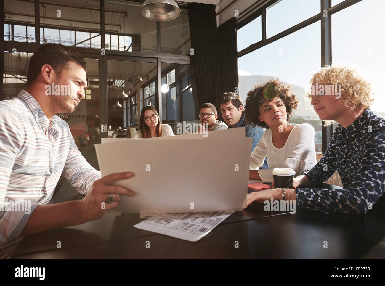 Glückliches und erfolgreiches Team von Kolleginnen und Kollegen zusammen zu sitzen, um Business-Pläne zu erarbeiten Stockfoto