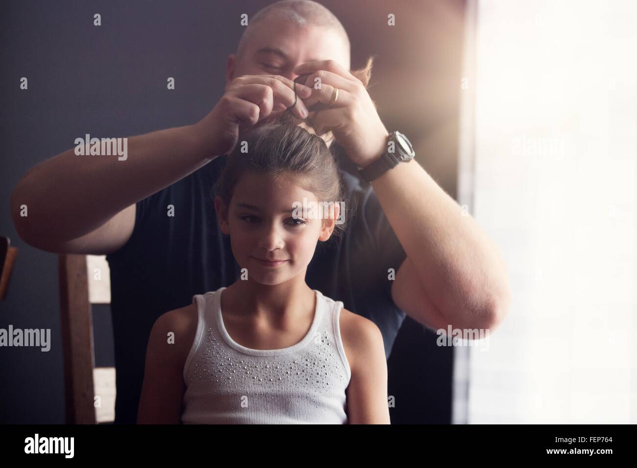 Vater seiner Tochter Haare tun Stockfoto