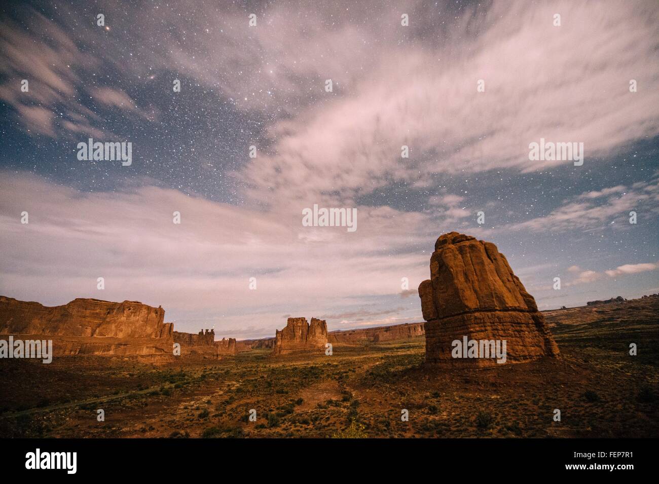 Wolken in sternenklaren Himmel und Tal Felsformationen bei Nacht, Moab, Utah, USA Stockfoto