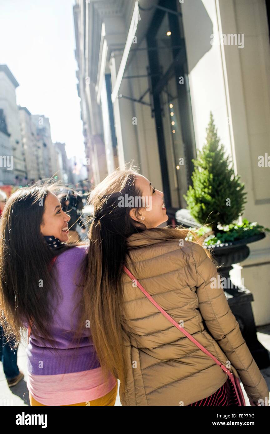 Rückansicht des jungen weiblichen Erwachsenen Zwillingen Schaufensterbummel in Stadt Stockfoto