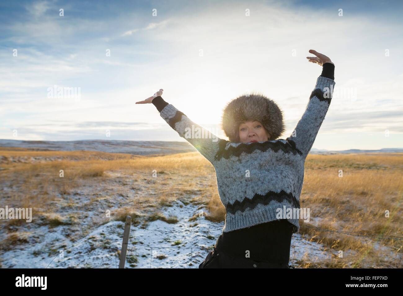 Reife Frau Arme kotzte auf schneebedeckten Feld, Island Stockfoto