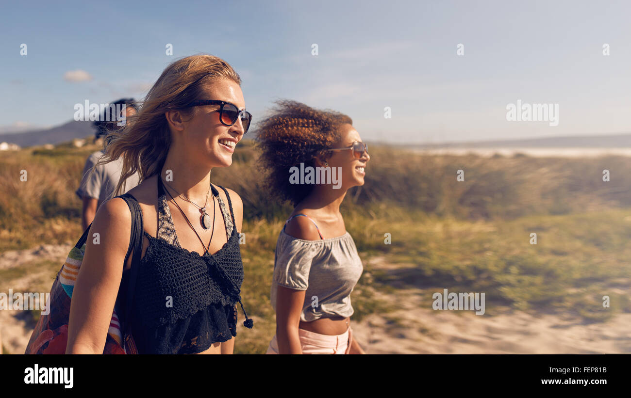 Porträt von lächelnden junge Frauen am Strand. Freundinnen am Ufer des Meeres an Sommertag, Strandurlaub. Stockfoto