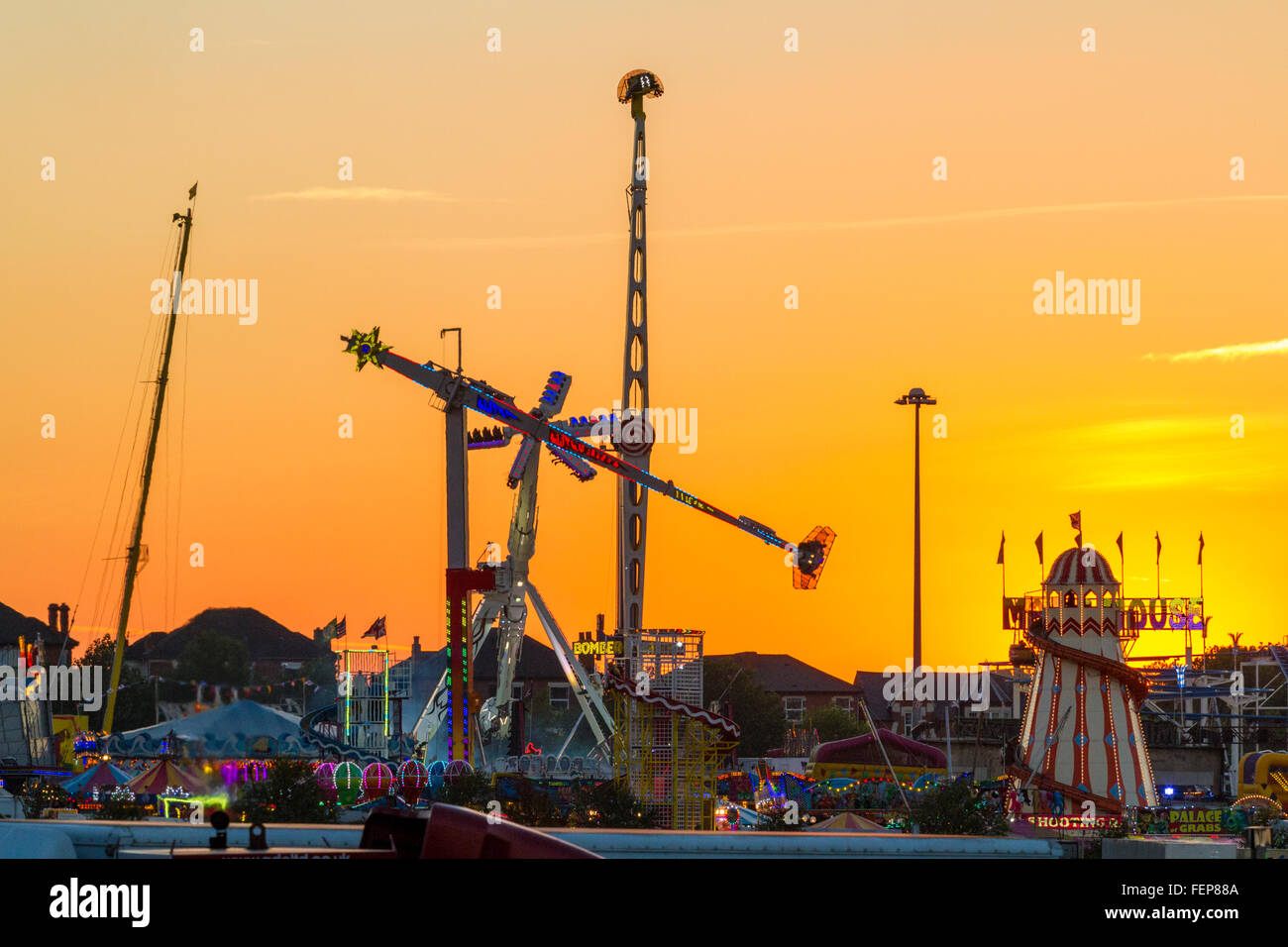 Kirmes vor einem Sonnenuntergang. Fahrgeschäfte in Nottingham Goose Fair, Nottingham, England, Großbritannien Stockfoto