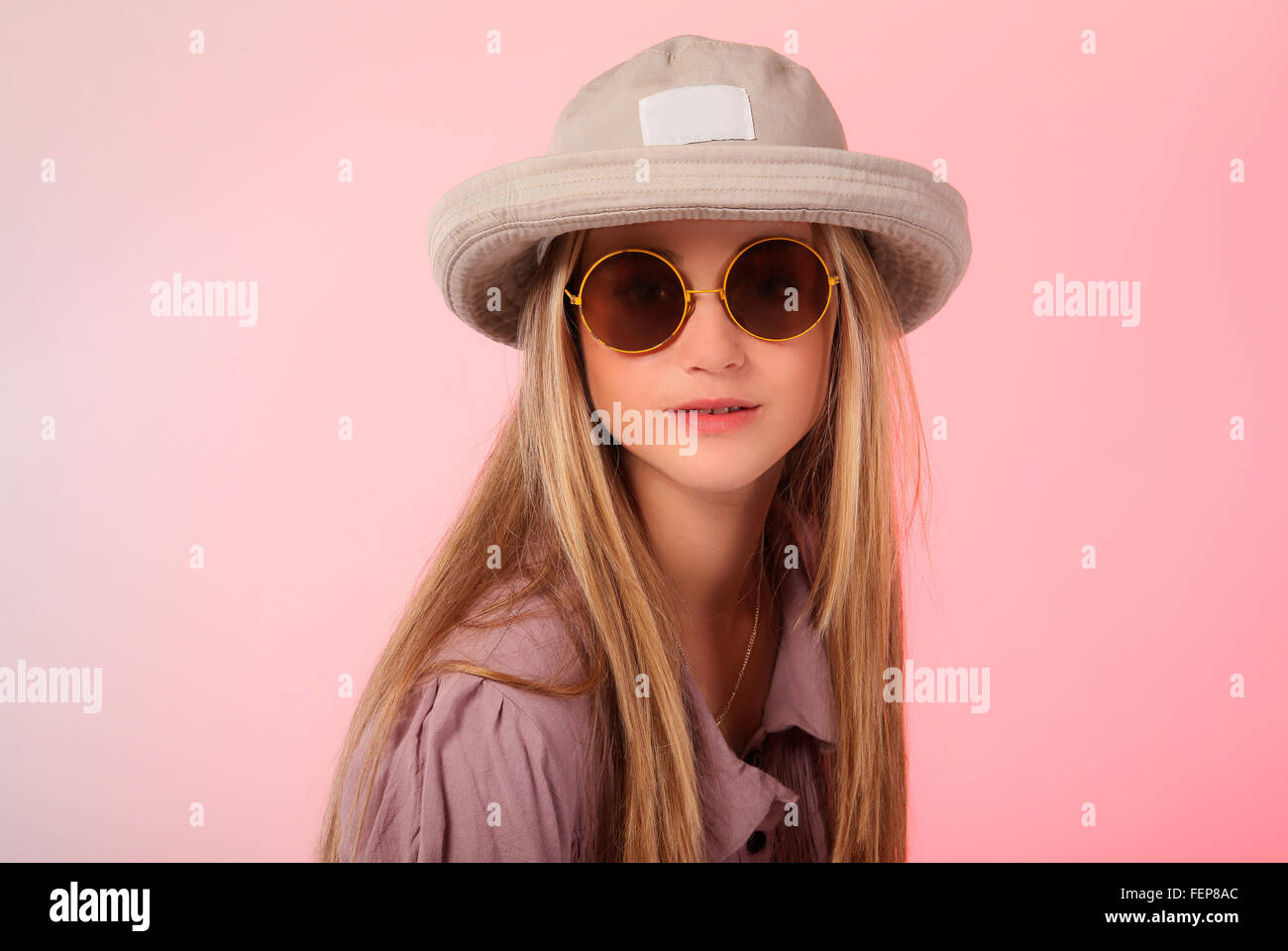 Eine schöne junge Teen blond Foto in einem Studio mit weichen rosa Hintergrund. Stockfoto
