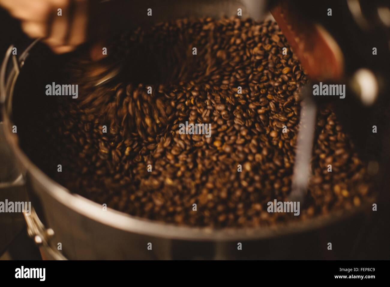 Mann mischen geröstete Kaffeebohnen Stockfoto