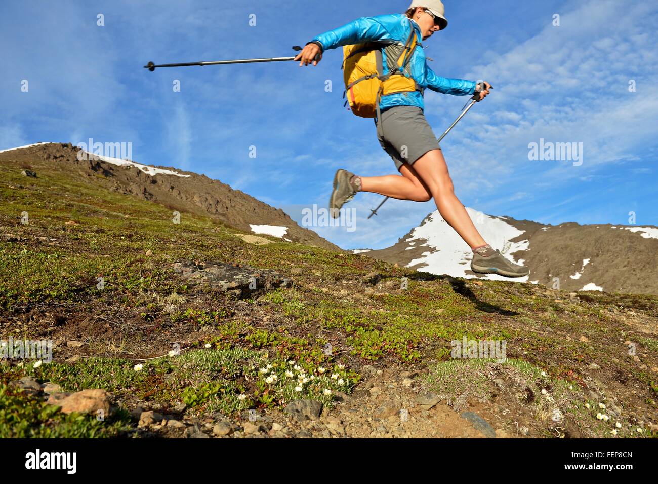 Weibliche Bergsteiger springen bergab, Chugach State Park, Anchorage, Alaska, USA Stockfoto