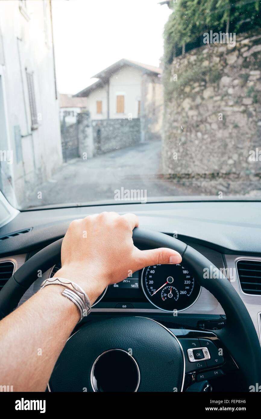 Hand am Lenkrad und Blick durch die Windschutzscheibe des schmalen  geschwungenen Straße, Luino, Lombardei, Italien Stockfotografie - Alamy