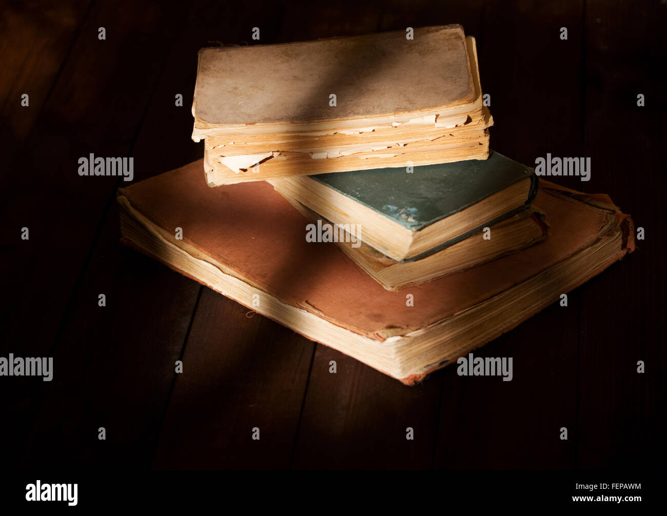 einige alte zerfetzt, lesen Sie Bücher über Holztisch auf das Licht vom Fenster fällt Stockfoto