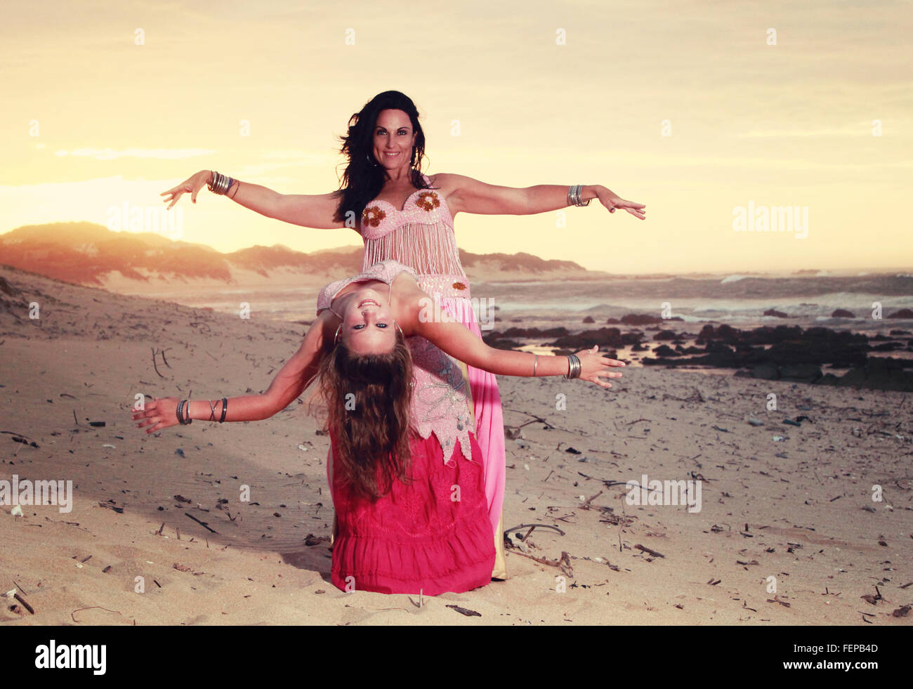 Eine gefilterte Jahrgang suchen Foto eines Bauchtänzerinnen-Mutter-Tochter-Duo am Strand von Afrika. Stockfoto