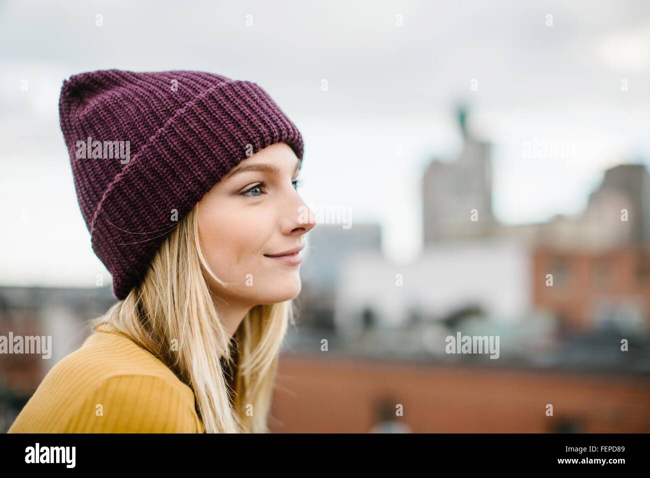 Porträt der jungen Frau mit gestrickte Mütze blicken Sie von Dach Stockfoto