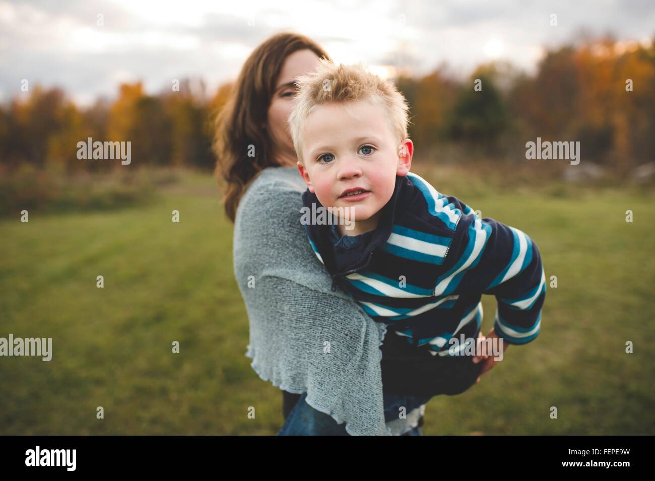 Sohn Mutter halten, stützte sich zukunftsorientiert in die Kamera Lächeln Stockfoto