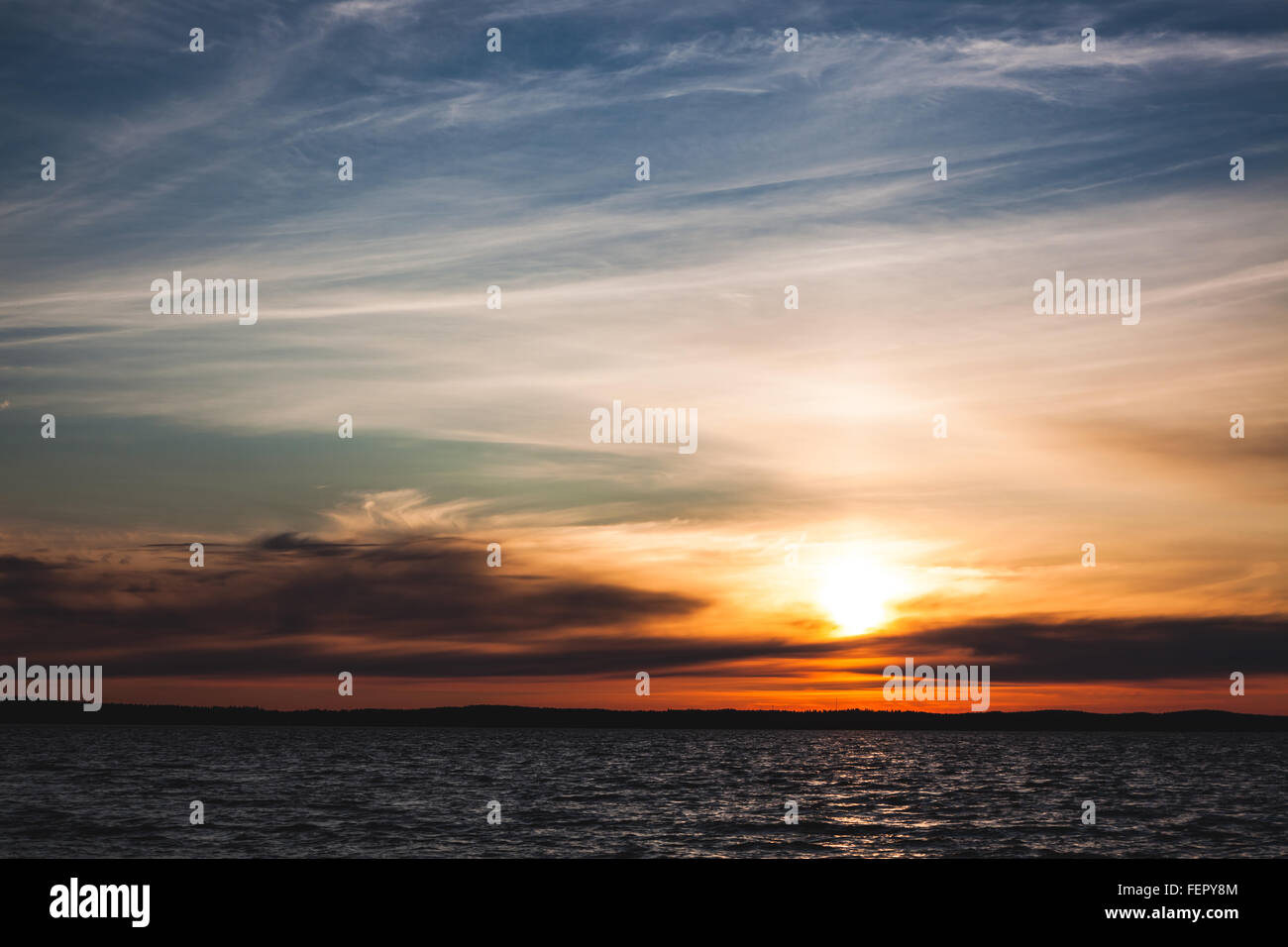 Wolken über See und ruhigen Sonnenuntergang Stockfoto