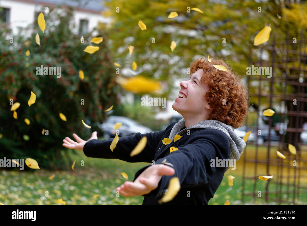 Teenager werfen Herbst Blätter, Deutschland Stockfoto