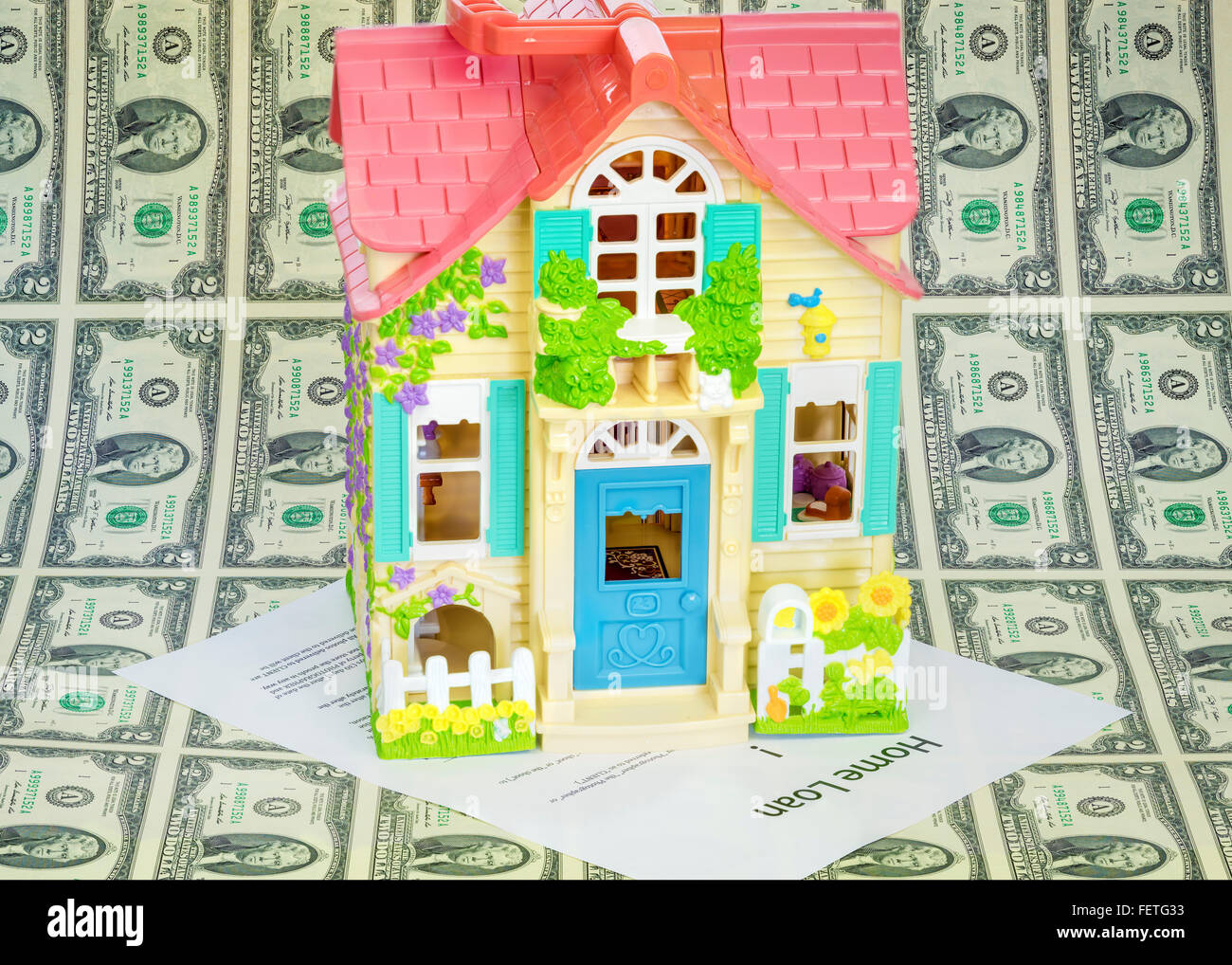 Spielzeug-Haus auf einem Blatt Geld mit nach Hause Stockfoto