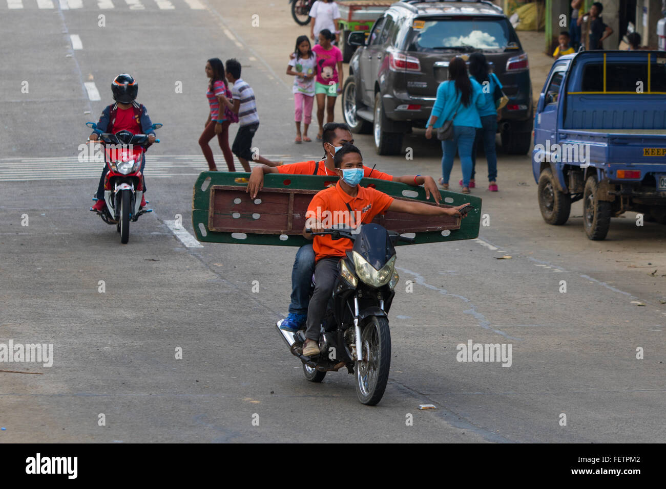 Filipino Sanitäter transportieren eine Bahre Board auf dem Motorrad. Handy-Fahrer halten. Stockfoto