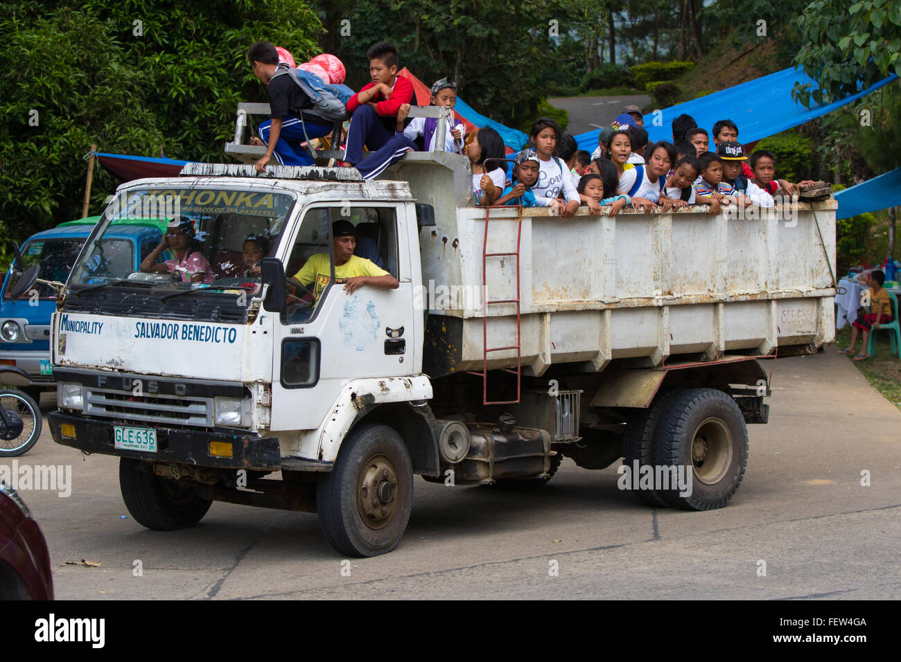 Gruppe von philippinischen Kindern hinter großen aufgedeckt Lkw unterwegs. Stockfoto