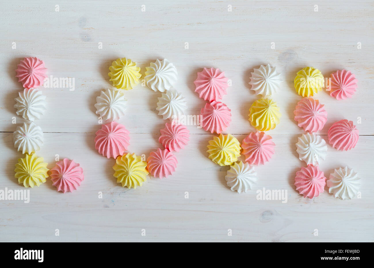Aufschrift Liebe Baiser gemacht der Pastell-Farben auf weißem Hintergrund aus Holz. Bild der Valentinstag Stockfoto