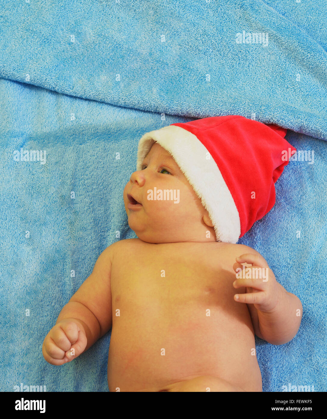 Portrait eines neugeborenen Jungen mit Weihnachtsmütze im Bett Stockfoto