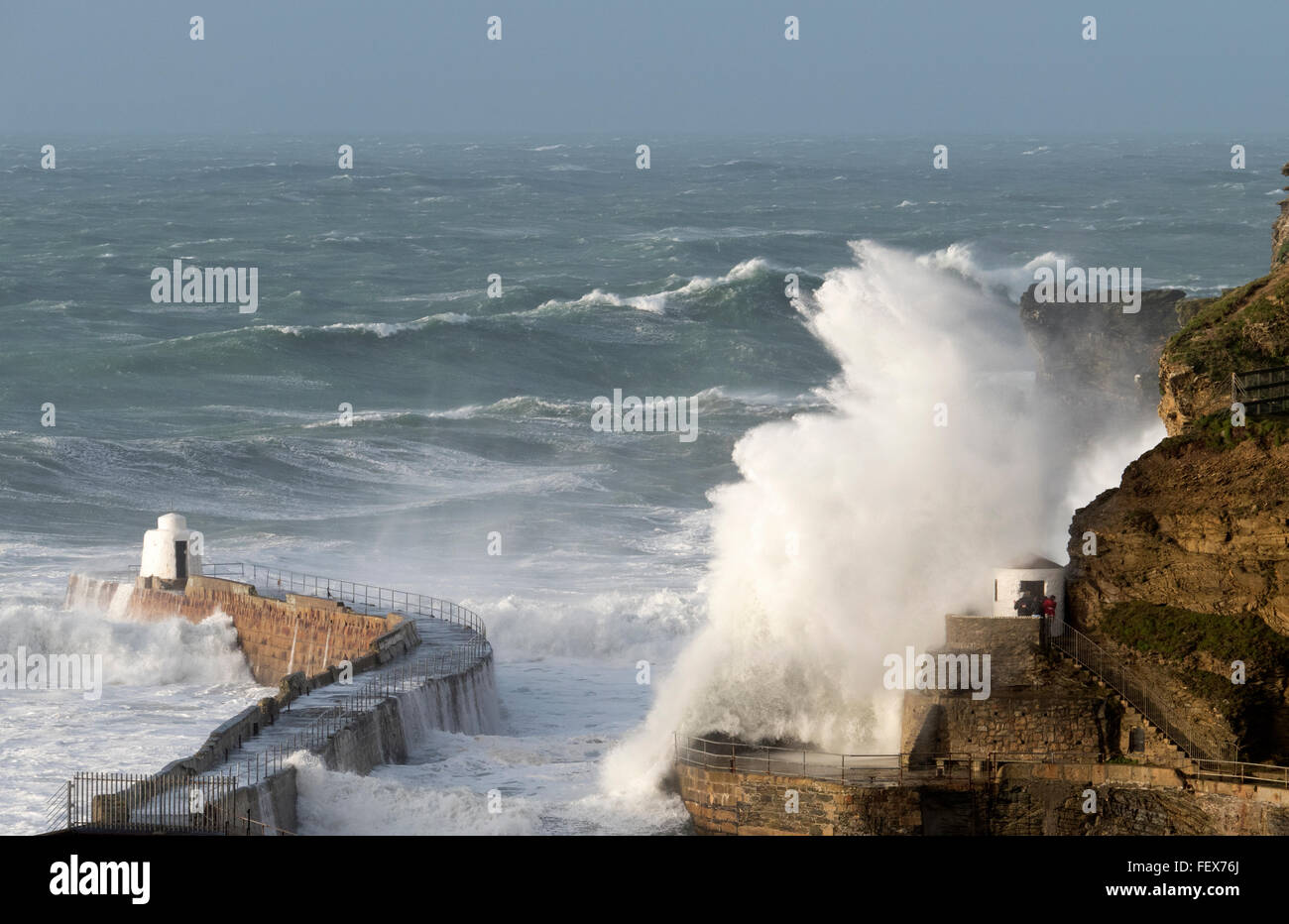 Portreath, Cornwall, England. Riesige Welle Splash schlagen der Hafenmauer und des toten Mannes Hütte bei Sturm Imogen. Stockfoto