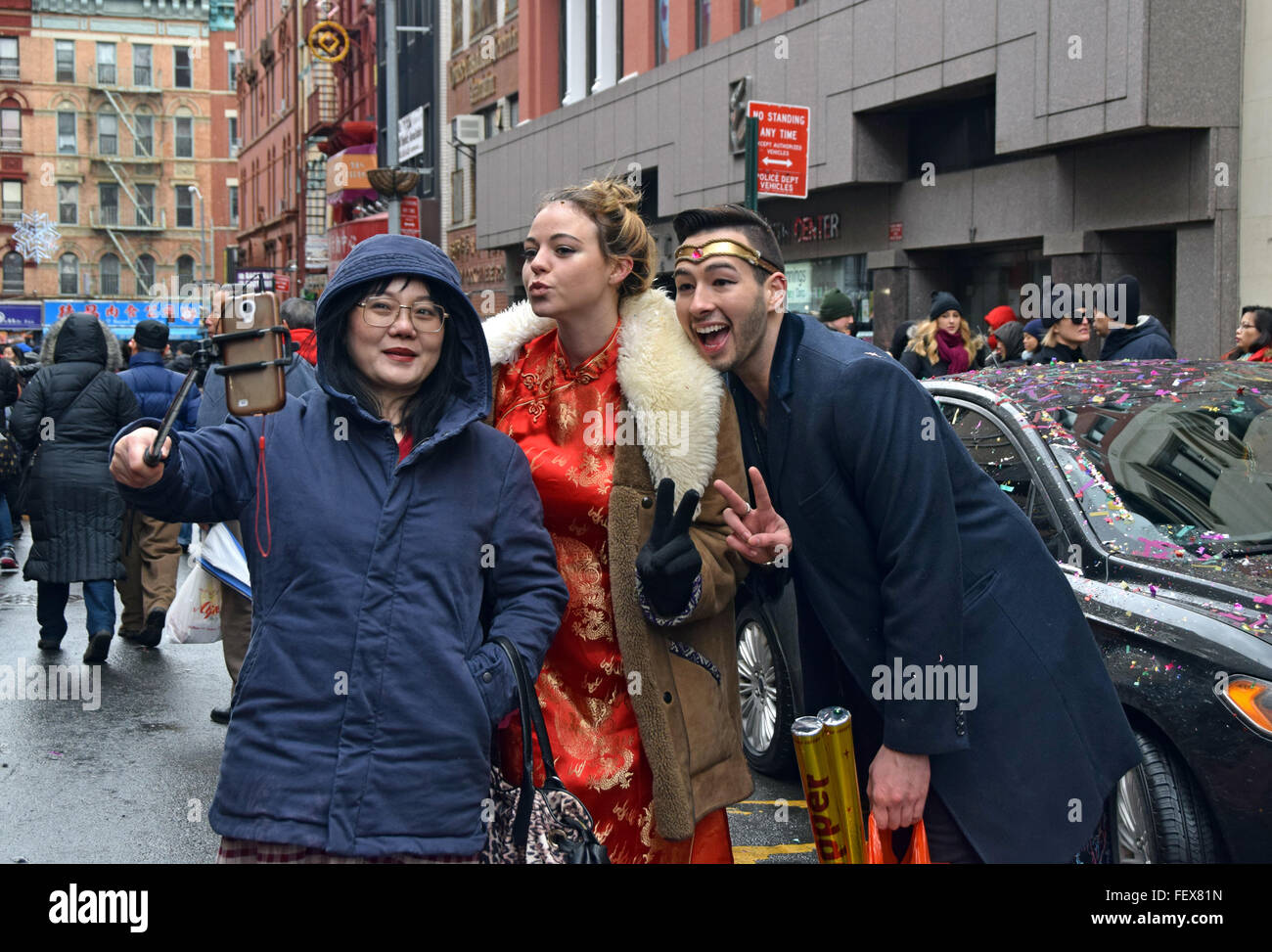 Eine asiatische Frau nimmt ein Selbstporträt mit 2 Caucasion Chinatown Einwohner am Tag des chinesischen Neujahrs Parade. In New York City Stockfoto