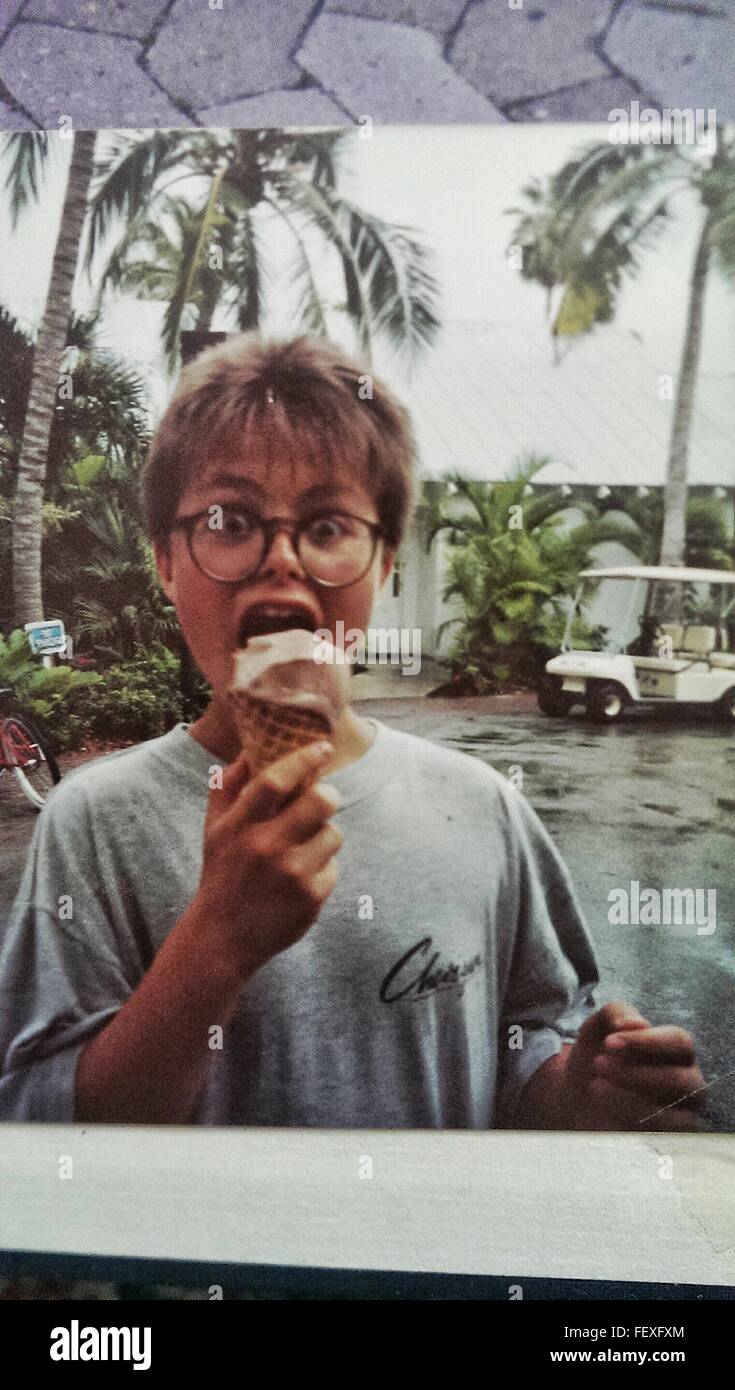 Porträt von gierigen Teenager tragen Brillen essen Eis gegen Palmen auf Straße Stockfoto