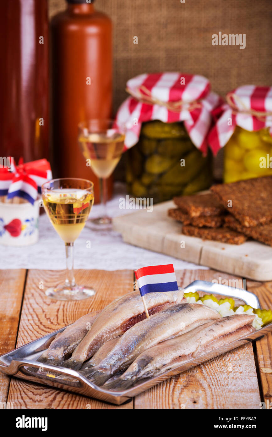 Hering mit Zwiebelwürfeln, Cornichons und Silberzwiebeln, serviert mit einem Schuss "Korenwijn" (Getreide Wein). Eine traditionelle niederländische deli Stockfoto