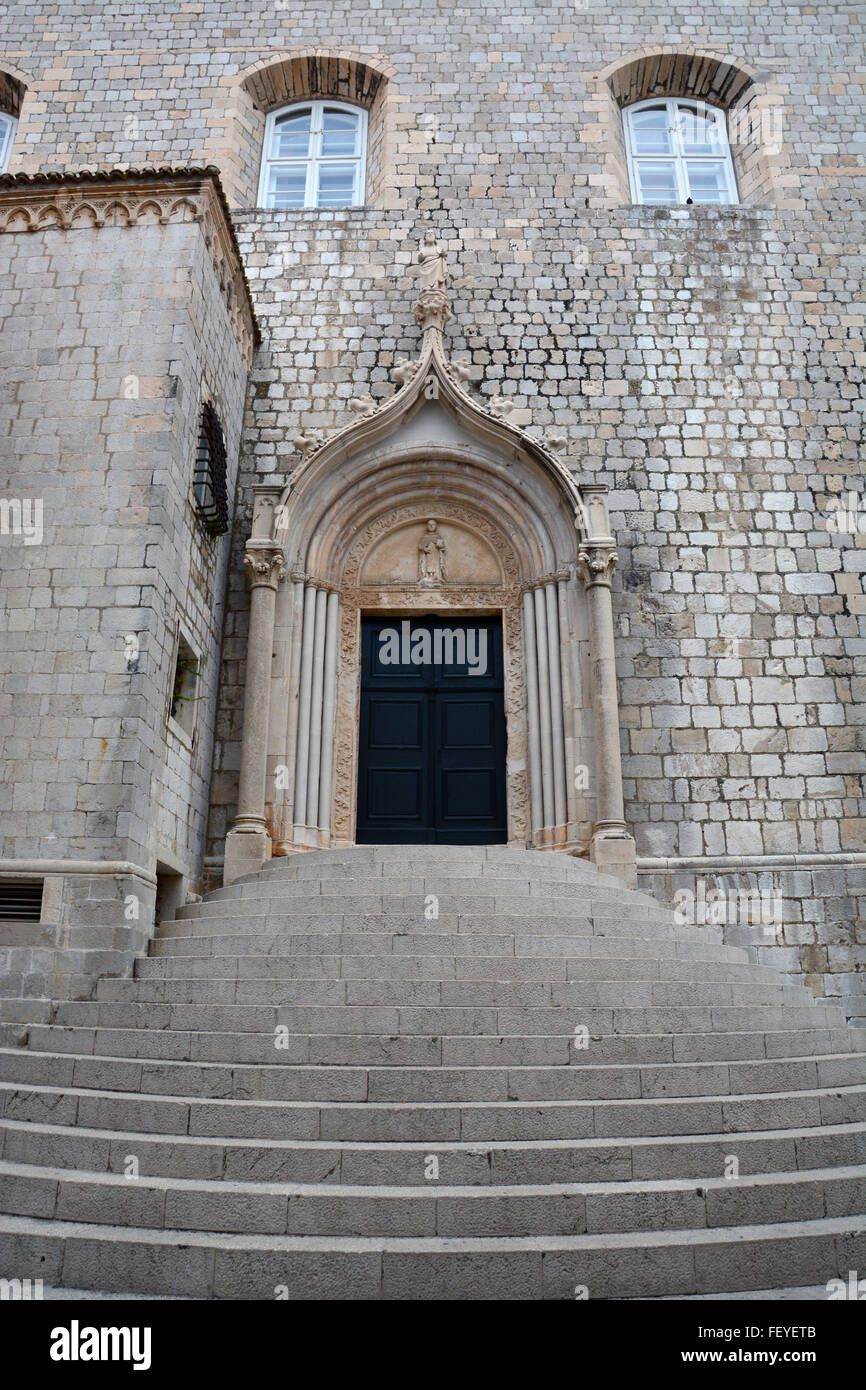 Über die geschwungene Treppe an der südlichen Tür des Dominikanerklosters in Dubrovnik steht eine Statue des St. Dominic. Stockfoto