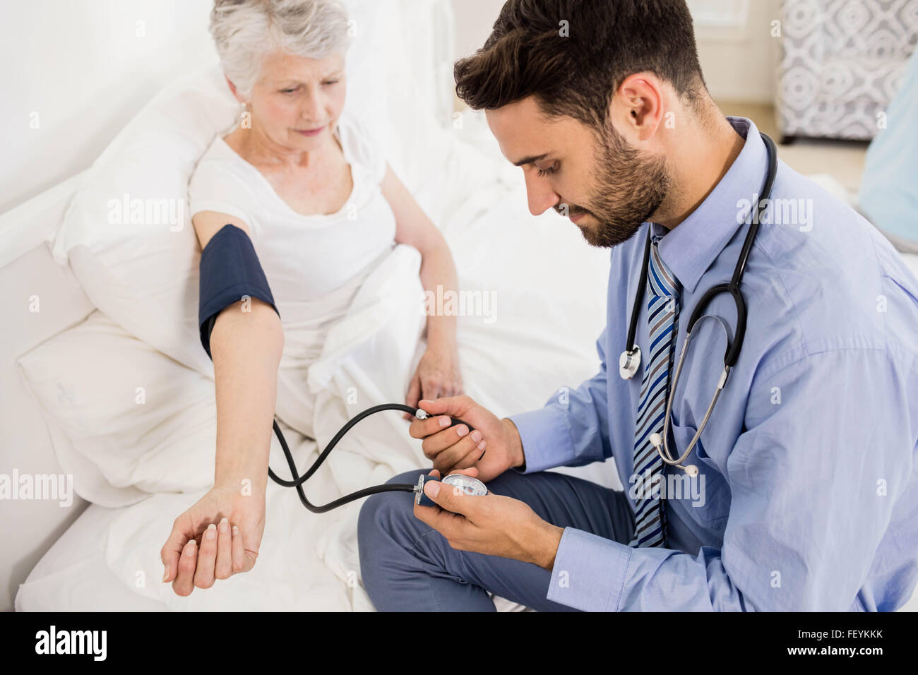 Hübsche Krankenschwester Blutdruck der Seniorin überprüfen Stockfoto
