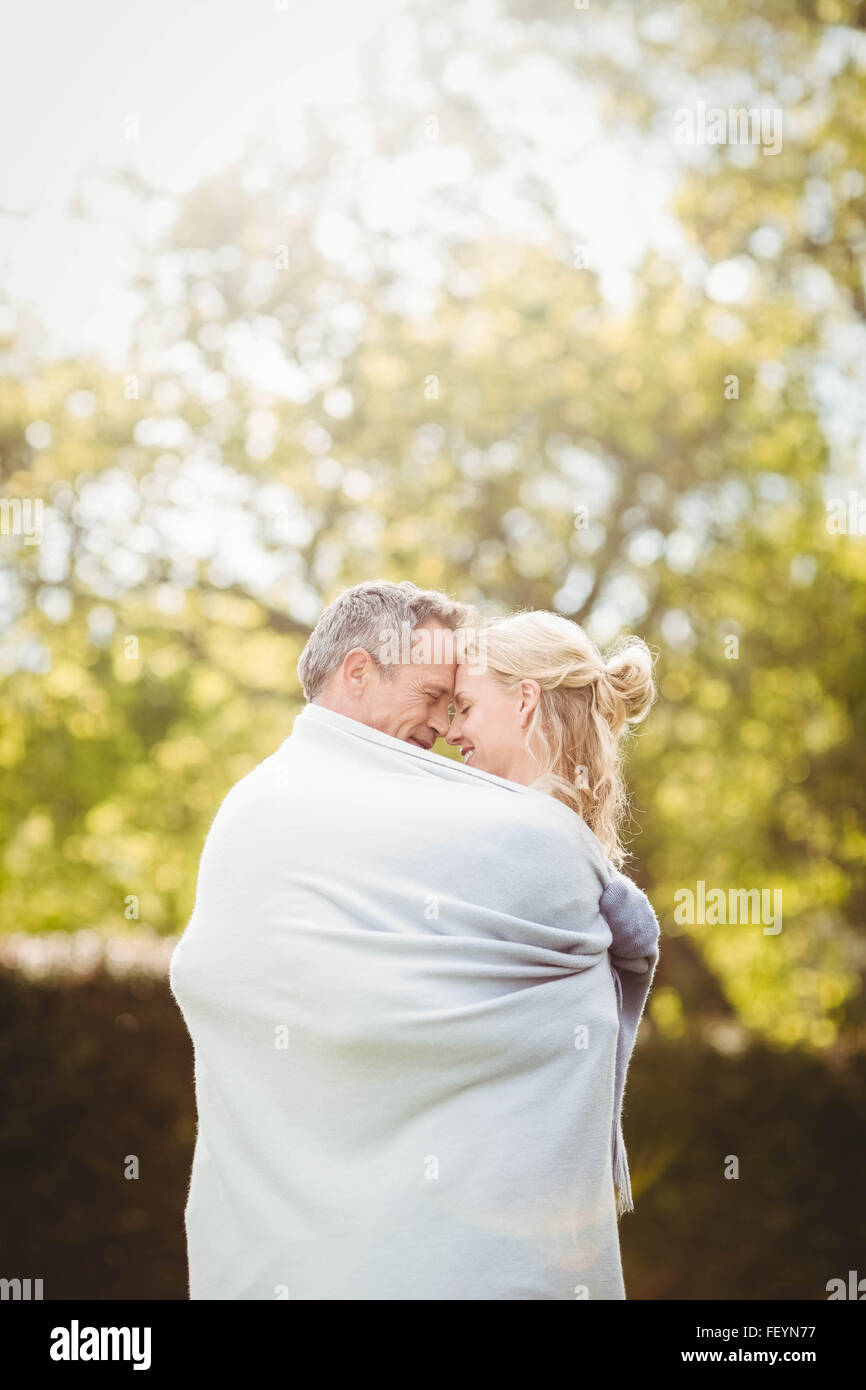 Nettes Paar mit einer Decke um umarmt Stockfoto