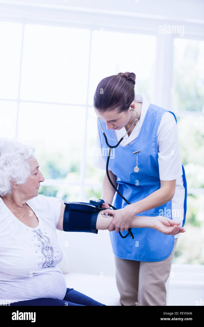 Krankenschwester kümmert sich um kranke ältere Frau Stockfoto