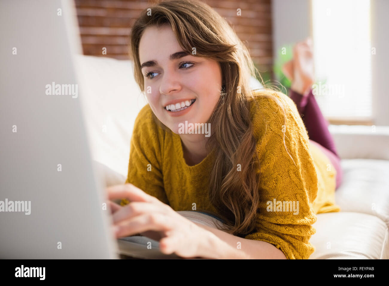 Lächelnde hübsche Frau mit laptop Stockfoto