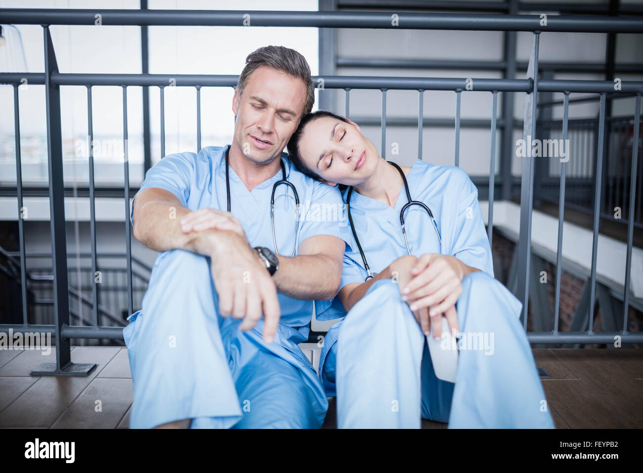 Müde Ärzteteam Einschlafen auf Etage Stockfoto