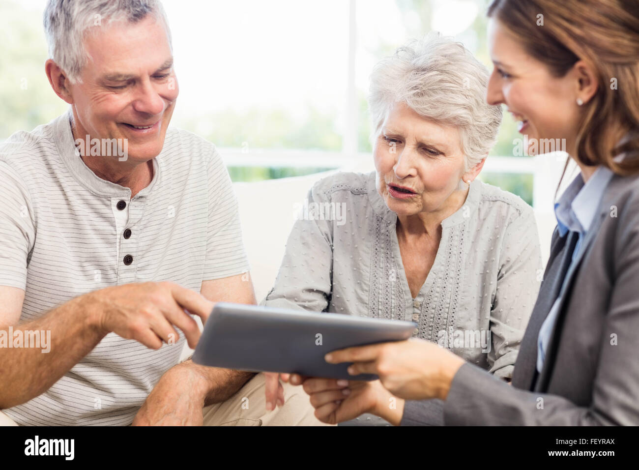 Geschäftsfrau zeigt Tablet, älteres paar Stockfoto