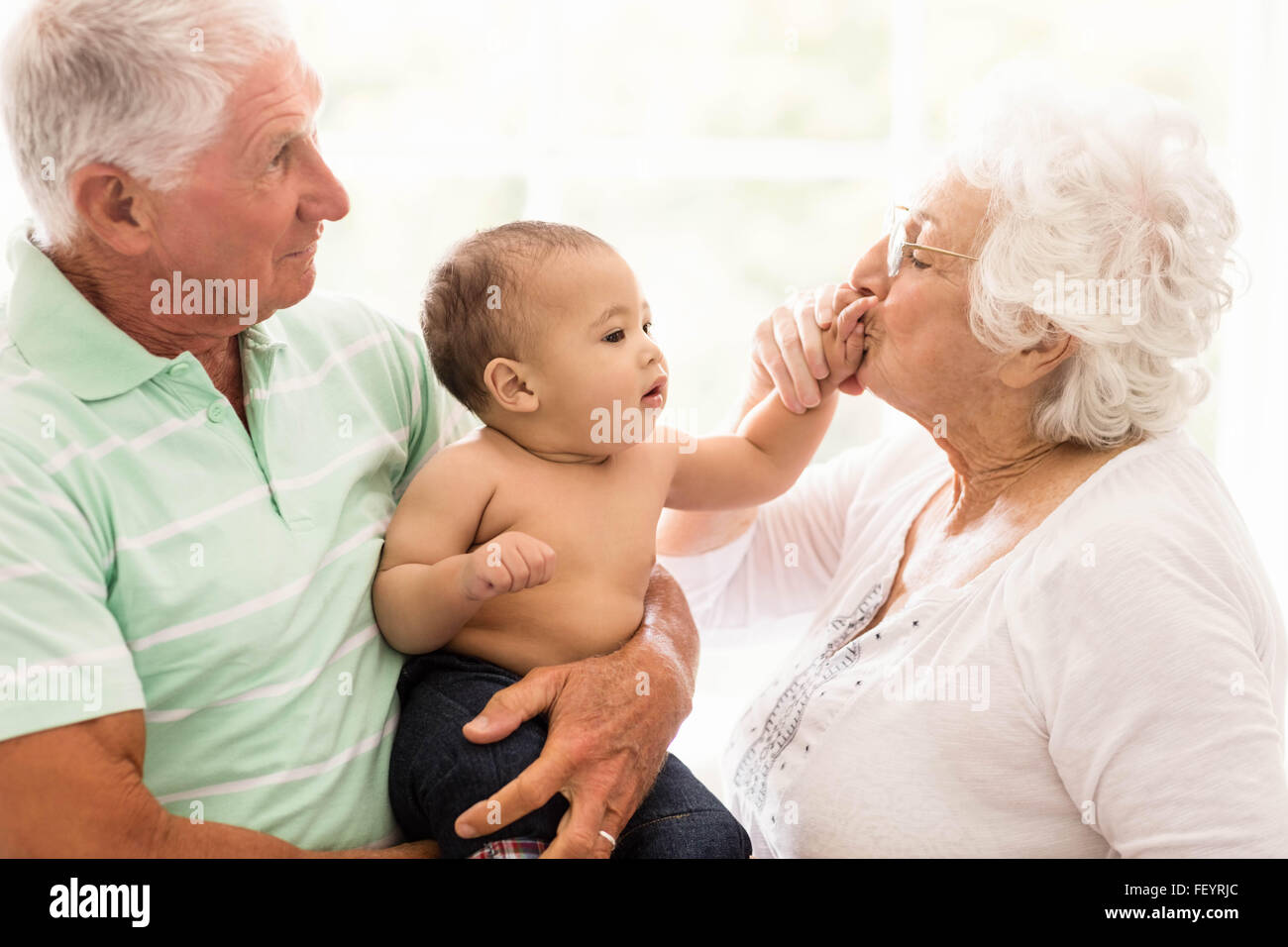 Glückliche Großeltern mit ihrem Enkel spielen Stockfoto