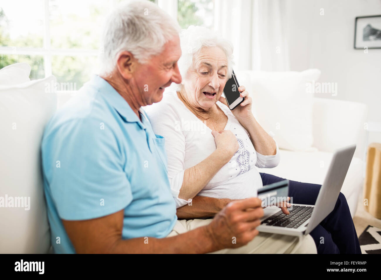 Lächelnde älteres Paar mit Laptop und smartphone Stockfoto