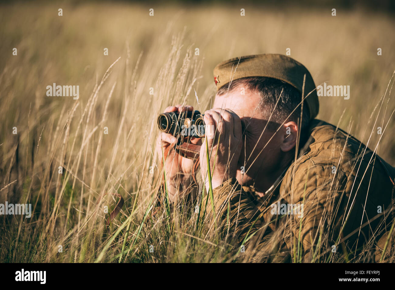 Nicht identifizierte Re-Enactor gekleidet als eine alte Armee Fernglas Sowjetsoldaten anschaut. Stockfoto