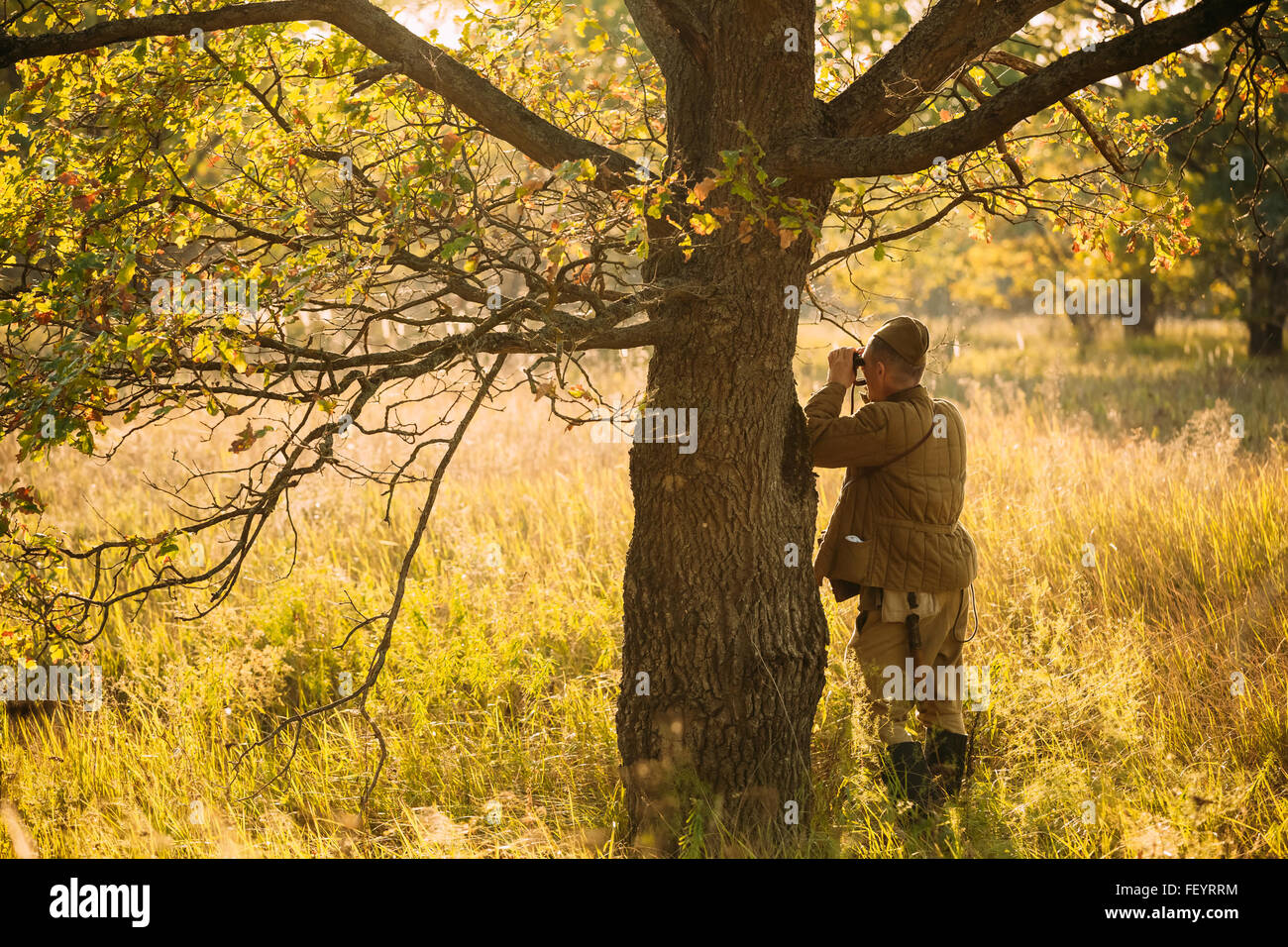 Nicht identifizierte Re-Enactor gekleidet wie ein Fernglas Sowjetsoldaten anschaut. Stockfoto