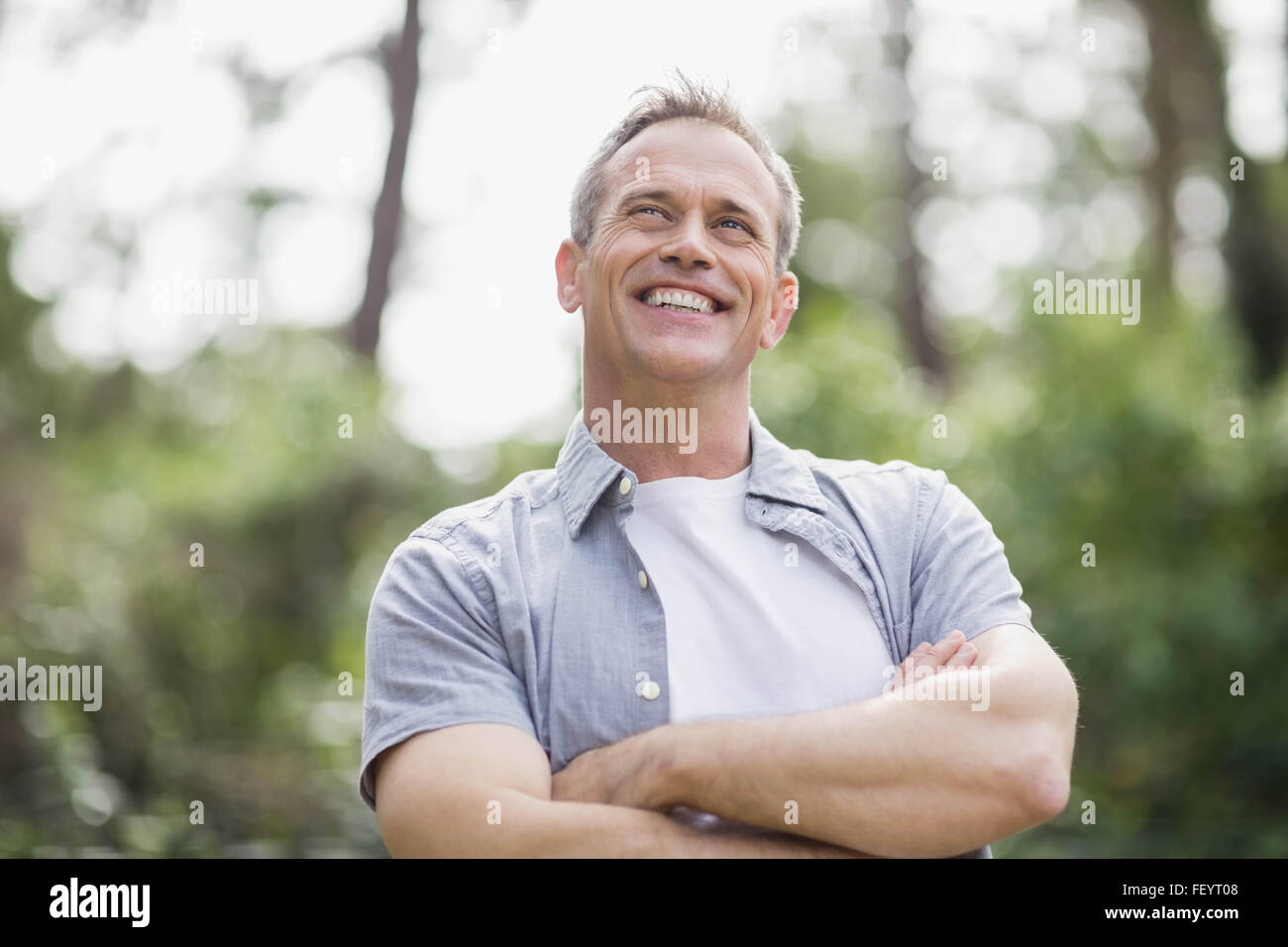 Lächelnder Mann seine Arme kreuzen Stockfoto