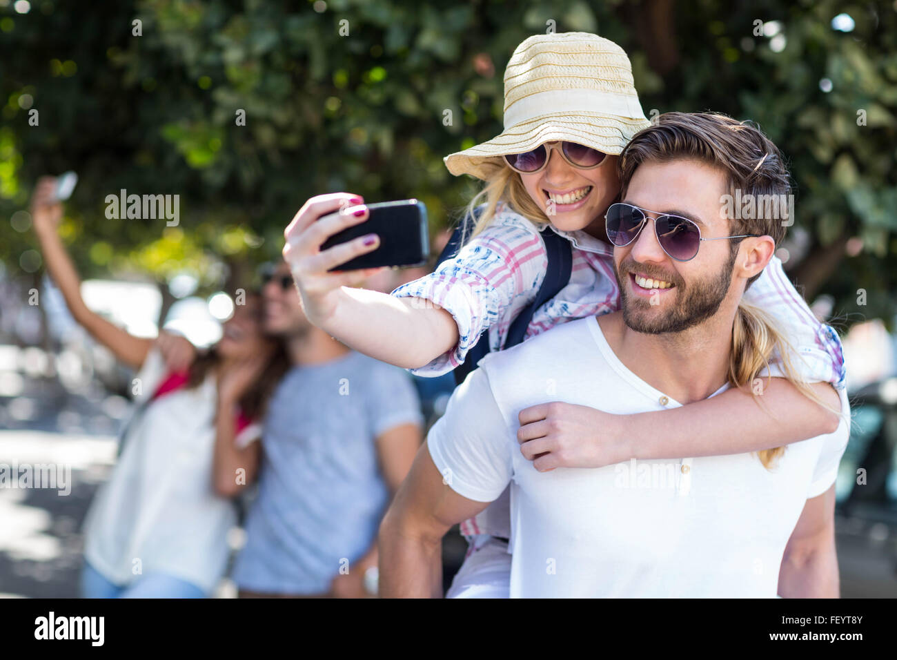 Hüfte Mann geben Huckepack zu seiner Freundin und nehmen selfie Stockfoto