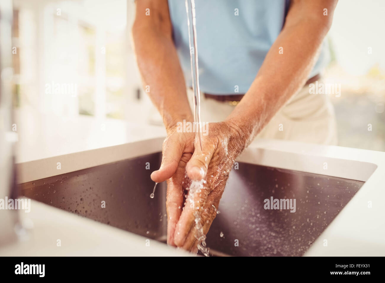Mittelteil des älteren Mannes Händewaschen Stockfoto