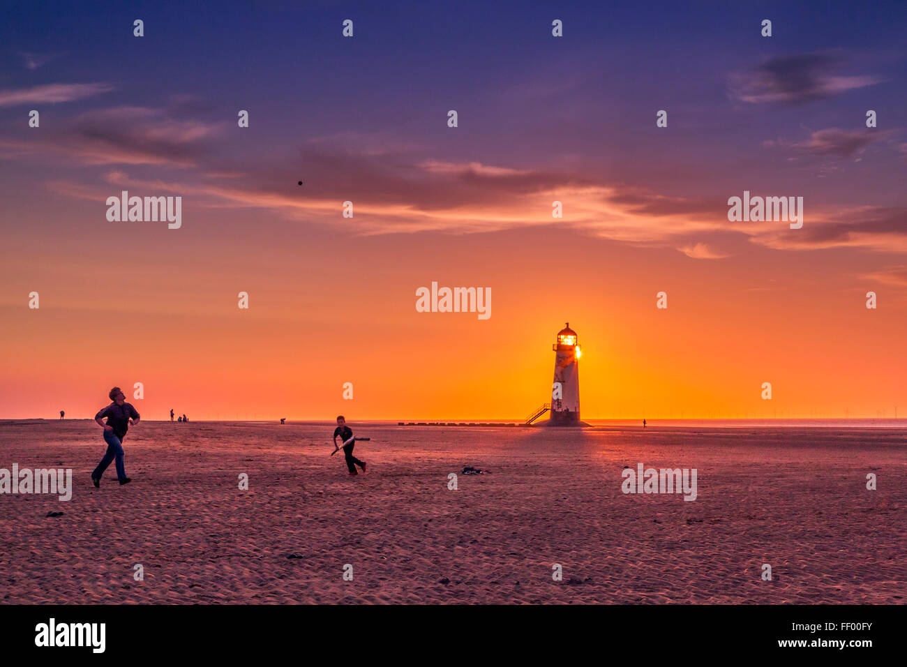 Spielen Sie Beach-Cricket auf Talacre Strand bei Sonnenuntergang. Stockfoto