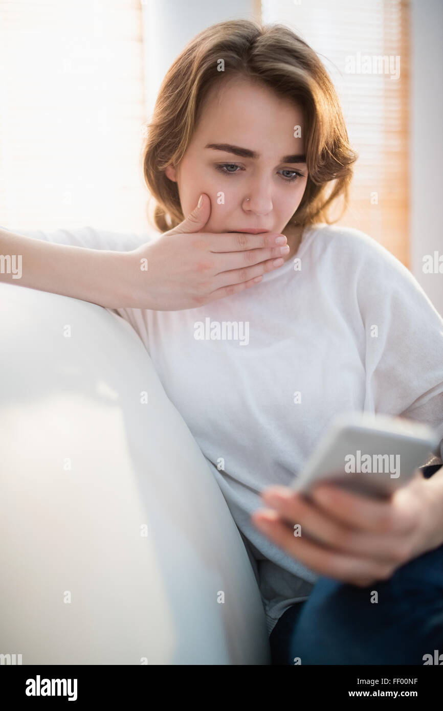 Hübsche Frau schockierenden Text zu lesen Stockfoto