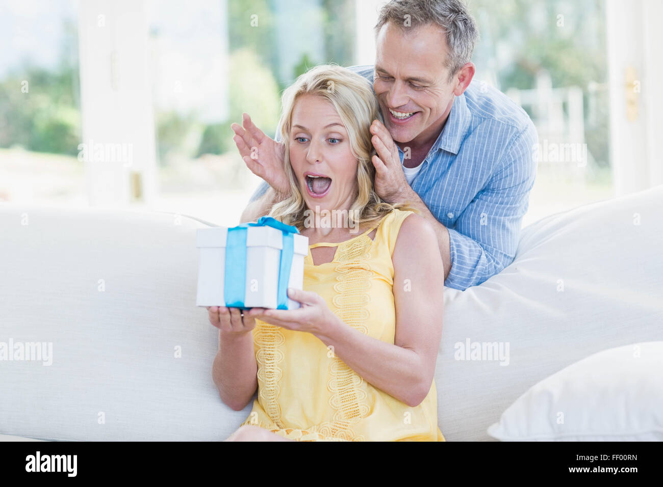 Mann, die Frau mit einem Geschenk zu überraschen Stockfoto